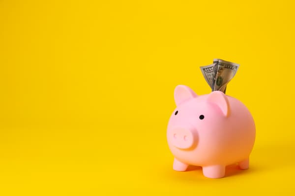 iStock Credit: skodonnell A piggy bank against a yellow background